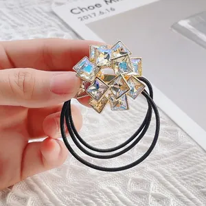 Détail d'un élastique à cheveux fleur en cristal avec triple liens et base dorée