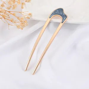 Macro view of U-shaped hair fork with grey marble enamel and rose gold metallic finish