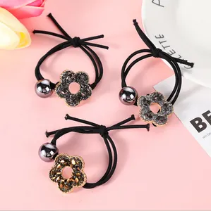 Detalle del set de 3 gomas de pelo con flores de diamantes y cuentas metálicas