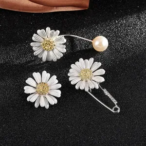 Minimalist daisy jewelry set with earrings and rhinestone brooch on premium silk background