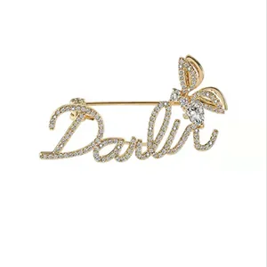 Detailed close-up of Darling letter brooch with sparkling rhinestones and insect wing