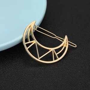 Detail view of a hollow moon-shaped golden alloy hair clip with a polished finish