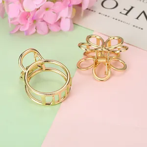 Détail de pinces à cheveux dorées en forme de fleur et cercle sur un fond pastel doux et élégant