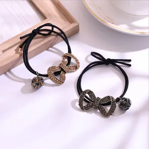 Detalle de gomas de pelo de alta elasticidad con mariposa de cristal y colgantes de metal