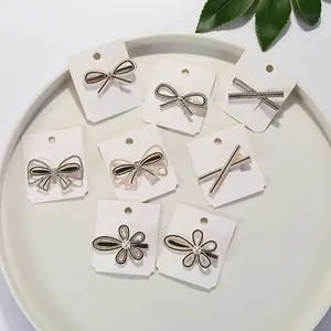 Set di 8 eleganti fermagli per capelli neri e oro con strass, perle e fiocchi su vassoio