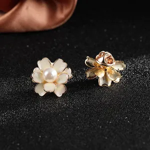 Macro detail of daisy brooch showing gold plated edges, white petals and pearl center