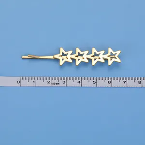 Fermaglio dorato con stelle a cinque punte traforate, lunghezza di circa 6,5-7 cm