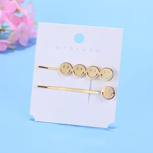 Set di fermagli per capelli dorati con sorrisi traforati in metallo su carta