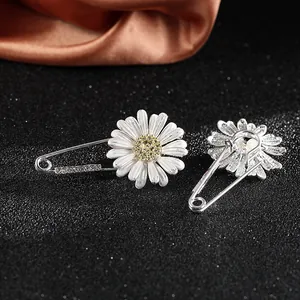 Detail of daisy brooch with white enamel petals, gold center and sparkling rhinestones