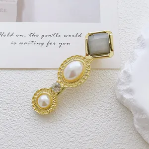 Detail of vintage gold alloy hair clip with oval pearls and square gray stone inlay