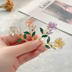 Floral hair clips with enamel petals and gold leaf detail in four elegant pastel colors