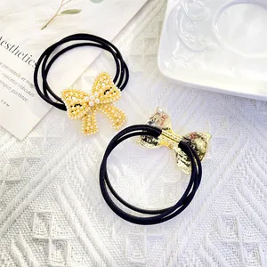 Elastic hair ties with pearl-studded metal bows shown in front and back views