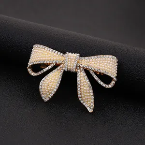 Elegante fermaglio per capelli a fiocco dorato con perle bianche e strass scintillanti