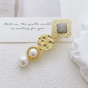 Detail of vintage gold hairpin with cat-eye stone, pearls and hammered metal texture