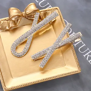 Dettaglio di eleganti fermagli dorati con strass bianchi e design a fiocco