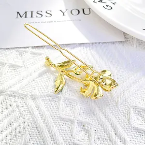 Detail of elegant gold flower hair clip with pearl texture on white lace background