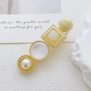 Detail of vintage gold alloy hair clip featuring faux pearls and cat eye stones