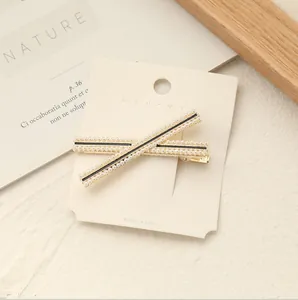 Dettaglio di eleganti fermagli per capelli con perle e base in metallo su cartoncino