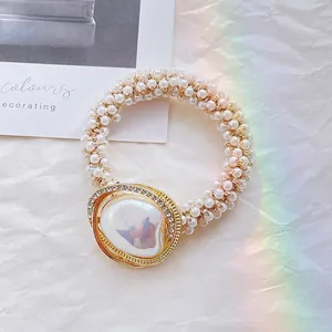Dettaglio di elegante elastico per capelli con perle e cornice dorata in cristallo