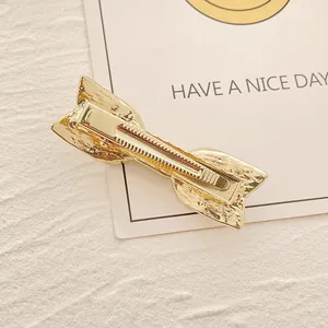 Eleganter goldener Metall-Haarclip mit Schleife und strukturierter Oberfläche hinten