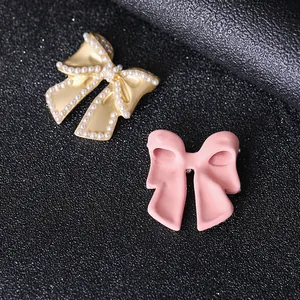 Elegant bow-shaped accessories in matte gold with pearls and smooth pink finish for DIY decor