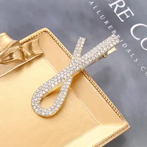 Macro di un fermaglio per capelli a fiocco dorato con strass lucidi su un vassoio