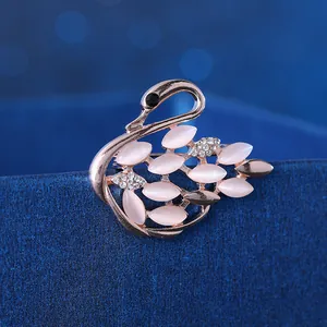 Detail of rose gold swan brooch with pink cat eye stones and sparkling zircons