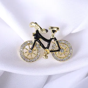 Elegant gold bicycle brooch with black enamel frame and sparkling rhinestones for women
