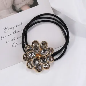 Detalle de goma de pelo con flor de cristal, diamantes ahumados y banda elástica