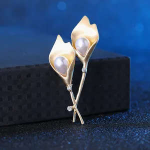 Detailed view of elegant gold Calla Lily brooch with white pearls and sparkling crystals