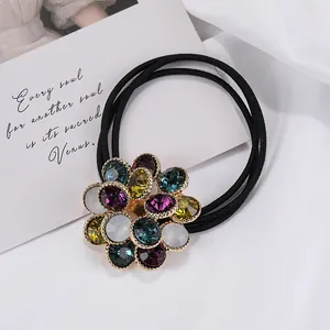 Primer plano de goma para el pelo con flor de diamantes de colores y bordes dorados
