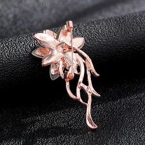 Macro shot of rose gold flower brooch back showing secure pin clasp and metal texture