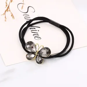 Detalle de lazo para el cabello de mariposa de cristal gris con cordón elástico negro