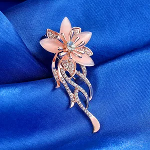 Detailed close-up of rose gold flower brooch with pink petals and inlaid crystals
