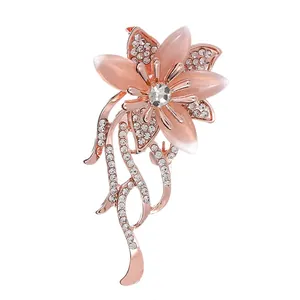 Macro shot of rose gold flower brooch with pink cat eye stone and sparkling crystals
