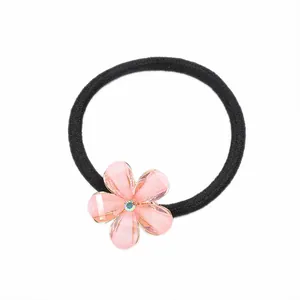 Élastique à cheveux avec un ornement floral rose et des strass aux reflets irisés