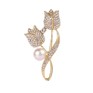 Detail of tulip brooch featuring white rhinestones, a central pearl, and gold-plated finish