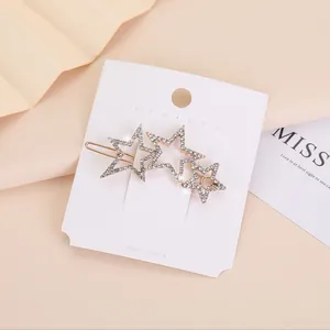 Dettaglio macro della molletta dorata a stella con strass luccicanti sulla confezione