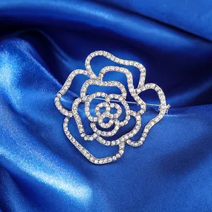 Broche rose argentée élégante avec strass sur fond en soie bleu foncé, design de luxe