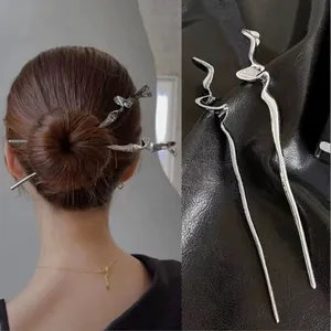 Détail de deux épingles à cheveux argentées à vagues irrégulières pour chignons élégants