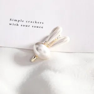 Detailopname van een schattige parel konijn haarclip met gouden strik en glimmende strass