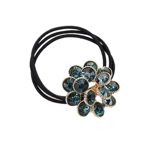 Coletero floral elegante con cristales azules sobre aleación dorada y triple goma negra