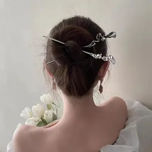 Pic à cheveux minimaliste en métal liquide argenté avec un design fluide et moderne