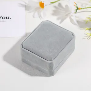 Closed grey velvet jewelry gift box with elegant octagonal corners and a minimalist design