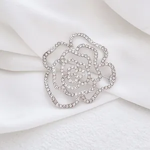 Détail macro d'une broche rose argentée avec strass scintillants et motif ajouré