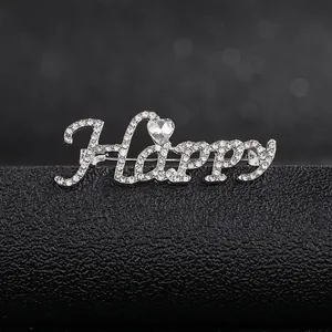 Macro shot of silver Happy brooch with sparkling rhinestones and a heart-shaped crystal