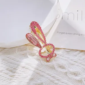 Exquisite gold bunny hair clip with pink crystals and pear-shaped gemstone on white knit