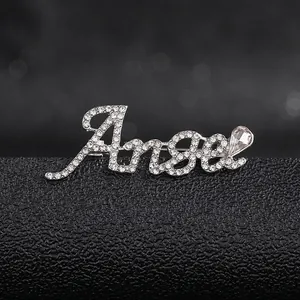 Macro shot of silver Angel letter brooch with sparkling rhinestones and drop crystal