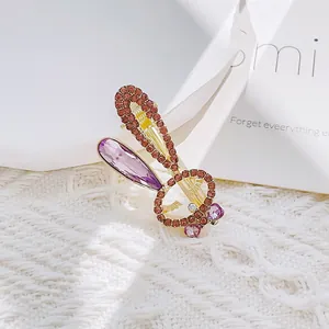 Detail of bunny hair clip with pink rhinestones and a large purple teardrop gem