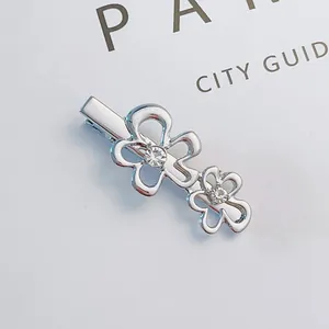 Detailed macro view of silver alloy flower hair clip with sparkling rhinestones and hollow design
